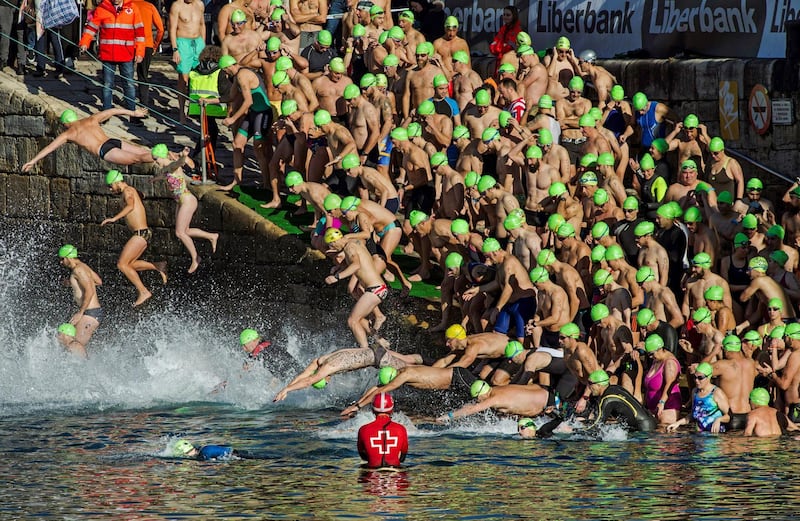 Swimmers jump into the water at the start of the Christmas Crossing 2017 in Gijon, Spain's second oldest Christmas swimming competition. Alberto Morante / EPA