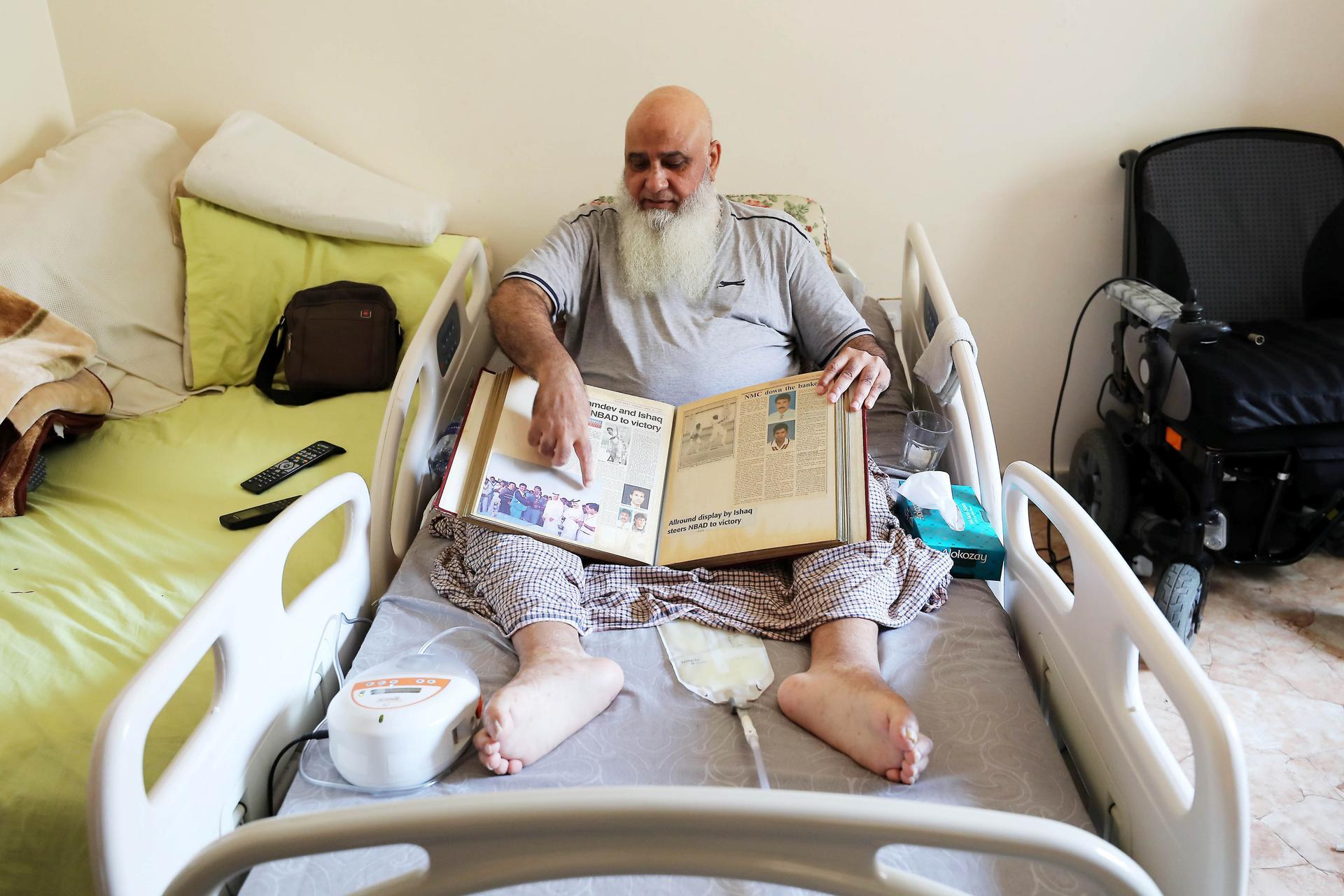 ABU DHABI,  UNITED ARAB EMIRATES , JUNE 17 – 2019 :- Mohammed Ishaq a player in the UAE's 1996 World Cup side, who is now wheelchair bound showing newspapers clipping at his home in Abu Dhabi. He is on wheelchair since a car crash in 2009. ( Pawan Singh / The National ) For Sport. Story by Paul