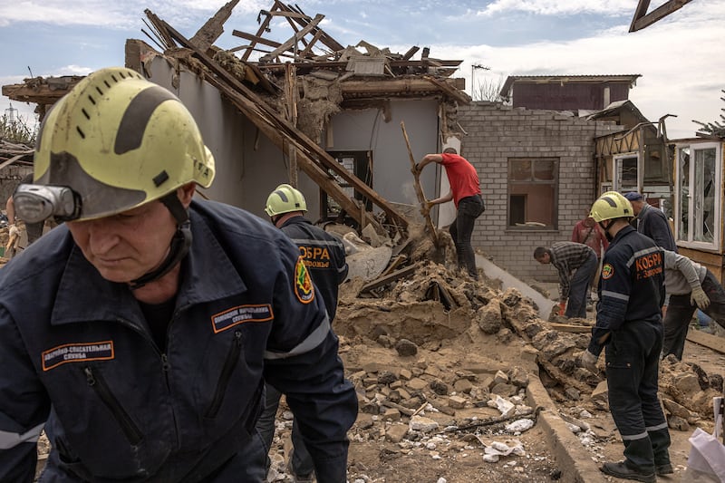 Residents and members of the Ukrainian emergency services clear debris after a recent Russian rocket attack in Zaporizhzhia, Ukraine.  EPA
