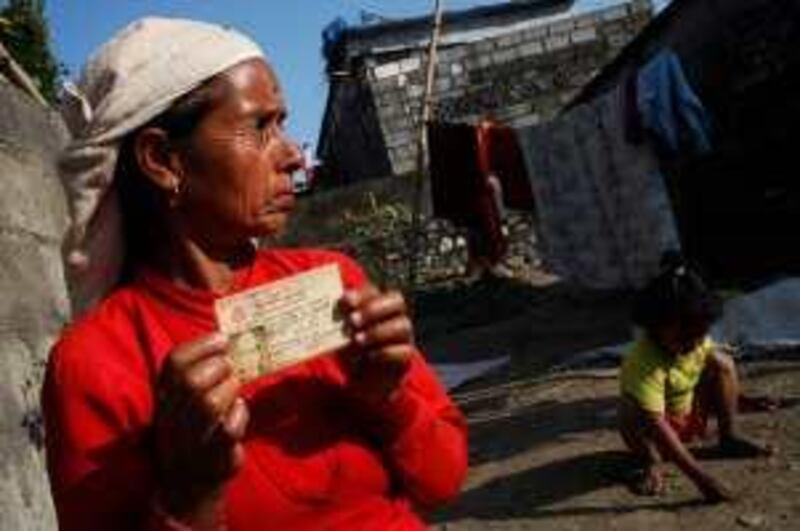 Jamuna Baral, 45, holds the citizenship card of her missing husband, Chama Lal Baral, in Pokhara, Nepal on Monday, February 16, 2009.  Mr. Baral, a bus driver and chairman of the Maoist party slum committee, is one of more than 1,200 people "disappeared" during the decade-long civil war between the Maoists and Nepal's royal government whose fate remains unknown. *** Local Caption ***  20090216_Nep_3827.jpg