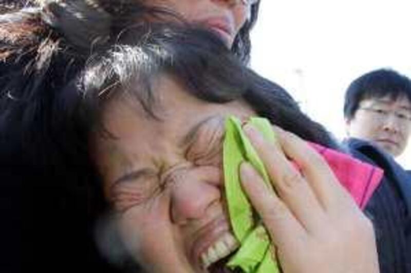 Family members of missing sailors the sunken South Korean naval ship Cheonan cry as they arrive in front of a naval base in Pyeongtaek, South Korea, Sunday, March 28, 2010. Military divers have searched in vain for the 46 marines missing since the South Korean ship exploded and sank near the tense maritime border with North Korea. (AP Photo/ Lee Jin-man) *** Local Caption ***  LJM107_South_Korea_Ship_Sinks.jpg *** Local Caption ***  LJM107_South_Korea_Ship_Sinks.jpg
