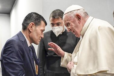 Pope Francis speaks to Abdullah Kurdi, whose son of Alan Kurdi drowned at the age of 3 when the family attempted a crossing to Europe in 2015, at the end of a Mass at the Franso Hariri Stadium in Erbil, Iraqi Kurdistan, on March 7, 2021. Vatican Media via AP