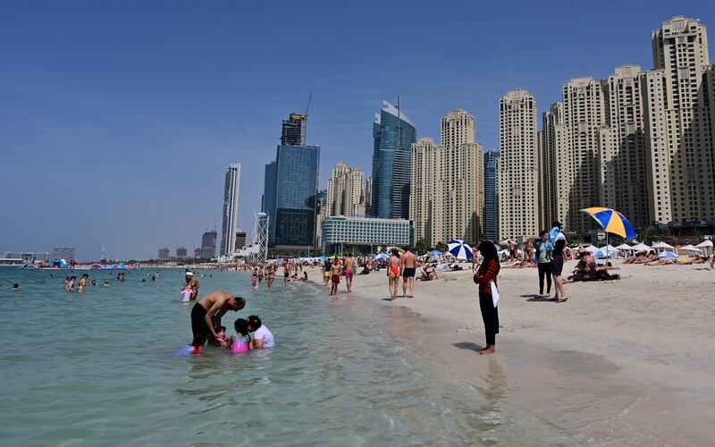 People swim in the water at Jumeirah Beach residence in Dubai on March 20, 2020 despite fears of the spread of COVID-19 coronavirus disease in the Gulf region. A series of unprecedented shutdowns to counter the fast-spreading coronavirus have impacted air travel, closing restaurants and cinemas and shutting down government and business offices in some Gulf states. / AFP / Giuseppe CACACE
