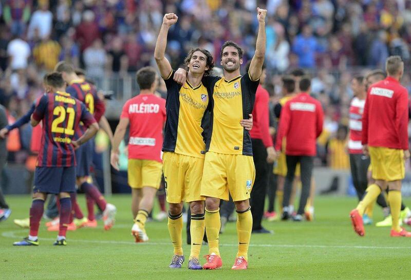 Atletico Madrid midfielder Tiago Mendes, left, and Atletico Madrid midfielder Raul Garcia celebrate their La Liga title at the end of Saturday's match with Barcelona. Josep Lago / AFP / May 17, 2014