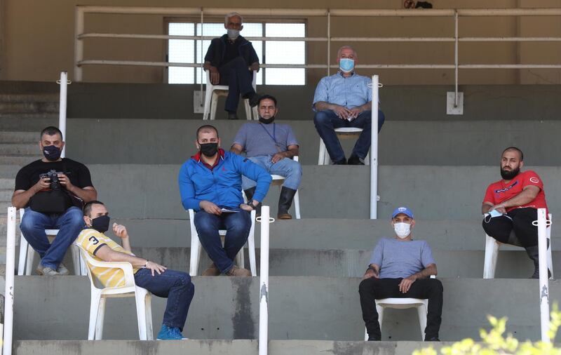 Hostlers and horse coaches wear face masks as they practice social distancing during a horse race at Beirut Hippodrome, as Lebanon re-opened its horse racing tracks, in Beirut, Lebanon. Reuters