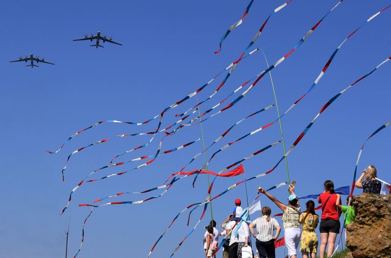 People watch Russian military aircrafts flying above the Gulf of Finland during the Navy Day parade at Kronshtadt near Saint Petersburg.   AFP / OLGA MALTSEVA