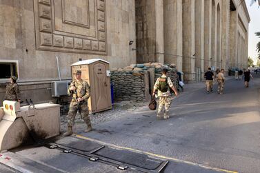 US Army soldiers (L), stand next to the former Ba'ath Party Headquarters near entrance to the International Zone on May 30, 2021 in Baghdad, Iraq. AFP