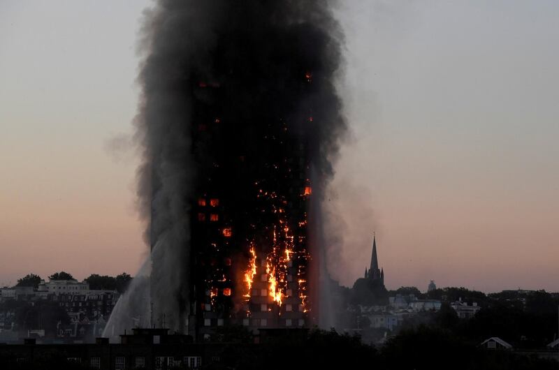 FILE PHOTO: Flames and smoke billow as firefighters deal with a fire in the Grenfell Tower apartment block in West London, Britain, June 14, 2017. REUTERS/Toby Melville/File Photo