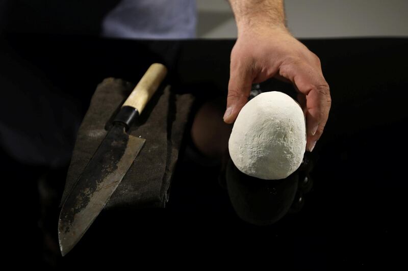 A worker helps Omar Sartawi, a Jordanian chef, as he recreates an ancient statue found in Jordan using a famous local product - Jameed (dried goatÕs milk used in the country's national dish), at his workshop in Amman, Jordan. REUTERS