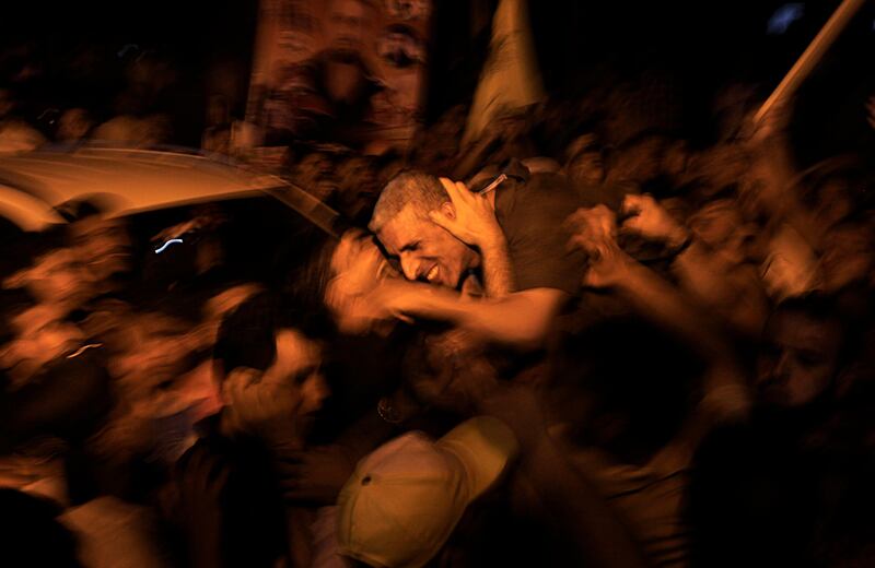 Freed Palestinian prisoner Ateya Abu Moussa (centre R), who was held by Israel for 20 years, hugs his relatives upon arrival at his family's house in Khan Younis in the southern Gaza Strip, early on August 14, 2013. Israel freed 26 Palestinian prisoners on August 14, hours before the two sides were to hold new direct peace talks amid a growing row over settlements.      AFP PHOTO / SAID KHATIB
 *** Local Caption ***  734264-01-08.jpg