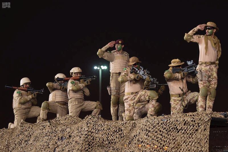 Members of Saudi security forces salute. SPA via Reuters