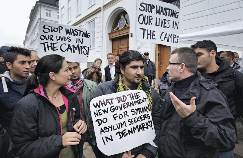 Some thirty Syrian refugees from different camps seeking asylum hold banners outside the Swedish Embassy in Copenhagen, Denmark on Wednesday, Sept. 26, 2012. The Syrians claim that Danes won't give them asylum because Denmark doesn't consider the civil war in Syria to affect all parts of Syria. Sweden gives a three-year temporary asylum to Syrians what ever part of Syria they come from.    (AP Photo/POLFOTO/Jens Dresling)  DENMARK OUT