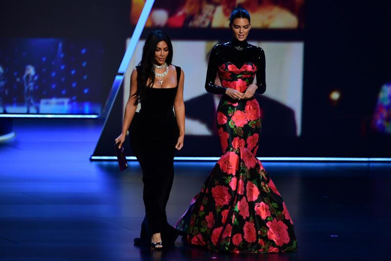 Kim Kardashian (L) in Vivienne Westwood and Kendall Jenner in Richard Quinn. AFP