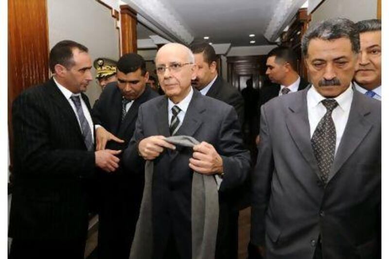 Tunisia's prime minister, Mohammed Ghannouchi, centre, with staff members near Tunis yesterday.