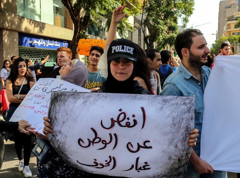 A Lebanese protester holds a placard reading in Arabic 'shake the dust of fear off homeland' during students protest in Beirut.  EPA