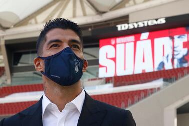 This handout picture released by Atletico Madrid shows Atletico Madrid´s new player Uruguayan forward Luis Suarez (L) posing on September 25, 2020 at the Wanda Metropolitano stadium in Madrid. RESTRICTED TO EDITORIAL USE - MANDATORY CREDIT "AFP PHOTO /HANDOUT ALBERTO MOLINA/ATLETICO MADRID/ " - NO MARKETING - NO ADVERTISING CAMPAIGNS - DISTRIBUTED AS A SERVICE TO CLIENTS / AFP / ATLETICO MADRID / Alberto Molina / RESTRICTED TO EDITORIAL USE - MANDATORY CREDIT "AFP PHOTO /HANDOUT ALBERTO MOLINA/ATLETICO MADRID/ " - NO MARKETING - NO ADVERTISING CAMPAIGNS - DISTRIBUTED AS A SERVICE TO CLIENTS