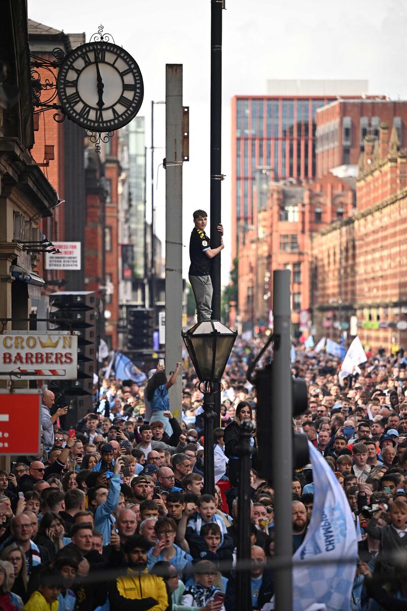 Manchester City fans wait for the open-top bus parade to start. AFP