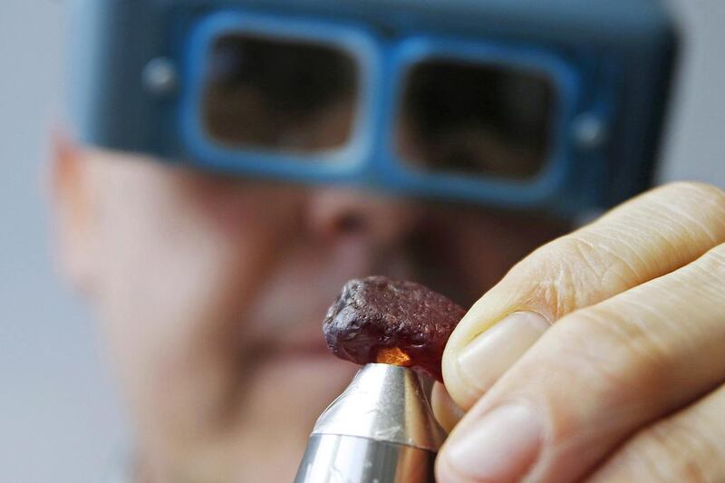 Ian Harebottle, chief executive of British precious stones miner Gemsfield, inspects a rare 40.23-carat rough ruby unearthed at its Montepuez deposit in Mozambique, during a rough ruby auction in Singapore on December 4, 2014. Edgar Su / Reuters