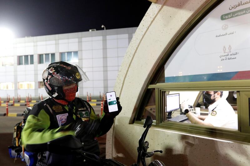 A Saudi motorbike rider shows his vaccination certificate as crosses the King Fahad Causeway. The country has seen a spike in cases since the Eid Al Fitr holidays. Hamad Mohammed / Reuters