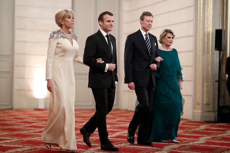 Brigitte, wearing a white silk Louis Vuitton gown with an embellished shoulder, with Emmanuel Macron, Grand Duke of Luxembourg Henri and his wife Maria Teresa, on March 19, 2018. AFP