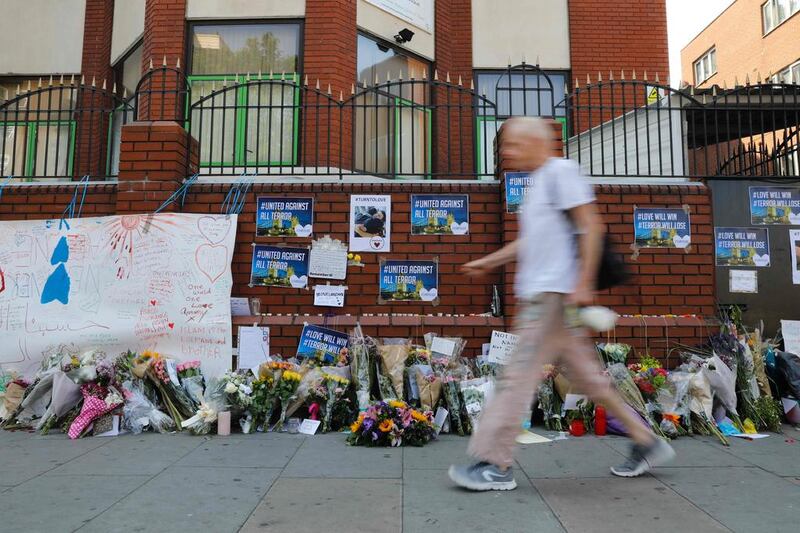 A man walks past flowers left outside Finsbury Park Mosque in north London. Tolga Akmen / AFP