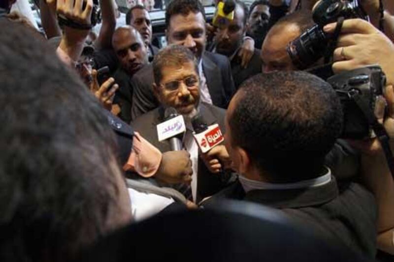 Mohammed Morsi, the Muslim Brotherhood's presidential candidate, is surrounded by reporters in Cairo, Egypt.