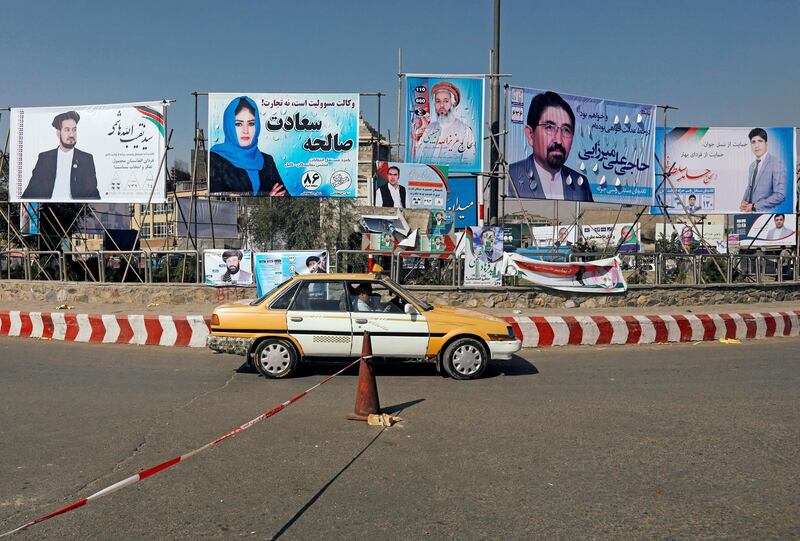 A vehicle drives in front of posters of parliamentarian candidates during the first day of a new election campaign in Kabul, Afghanistan. Reuters