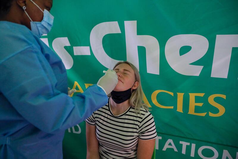 A healthcare worker tests a passenger at OR Tambo International Airport in Johannesburg. Several countries across the world have banned ban flights from southern Africa following the discovery of the Omicron variant. AFP