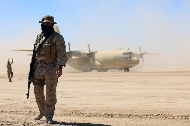 TOPSHOT - Saudi soldiers stand guard as a Saudi air force cargo plane, carrying aid, lands at an airfield in Yemen's central province of Marib, on February 8, 2018. / AFP PHOTO / ABDULLAH AL-QADRY