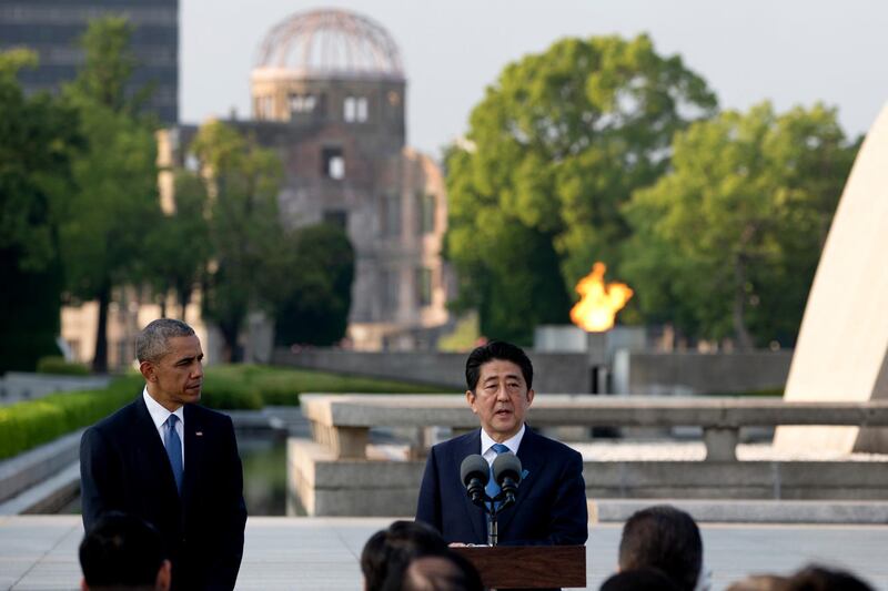 Former US President Barack Obama, left, looks to Japanese Prime Minister Shinzo Abe as he speaks during a ceremony at the cenotaph at Hiroshima Peace Memorial Park in Hiroshima, western, Japan, on May 27, 2016. Carolyn Kaster / AP