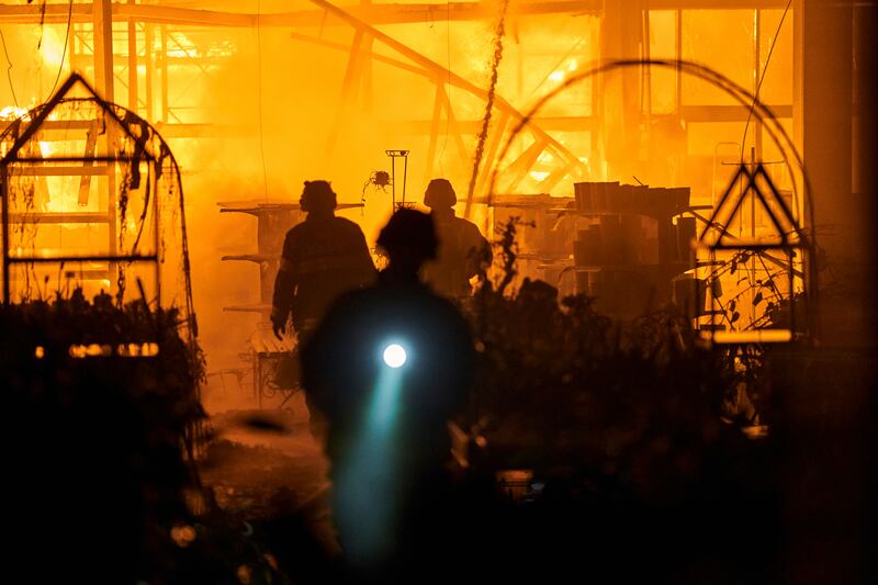 Firefighters put out a blaze after Russian shelling hit a shopping centre in Kherson, Ukraine. AP 