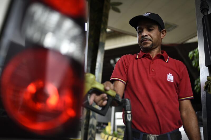 An employee refuels a vehicle at a Petroleos de Venezuela SA (PDVSA) gas station in Caracas, Venezuela, on Tuesday, Jan. 29, 2019. President Donald Trump sanctioned Venezuela's state-owned oil company PDVSA and its central bank on Monday, the latest U.S. move intended to raise pressure on the regime of President Nicolas Maduro. Photographer: Carlos Becerra/Bloomberg