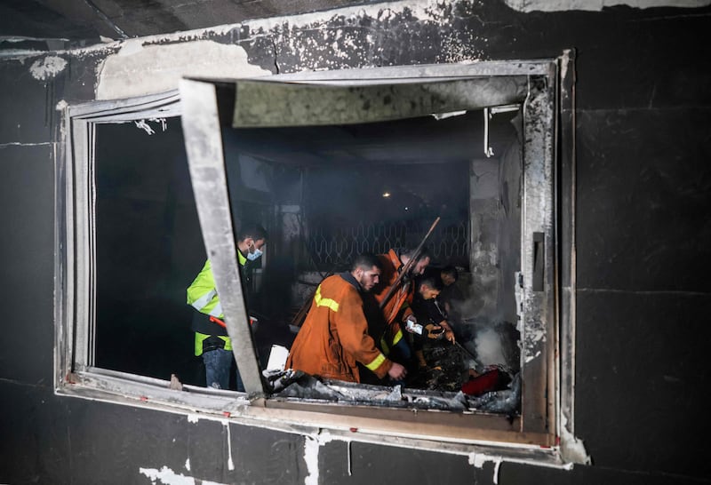 Palestinian firefighters extinguish flames in an apartment ravaged by fire in the Jabalia refugee camp in the northern Gaza strip, on November 17, 2022.  - A large fire that ripped through a home north of Gaza City killed at least 21 people, including seven children, official and medical sources said.  (Photo by MAHMUD HAMS  /  AFP)