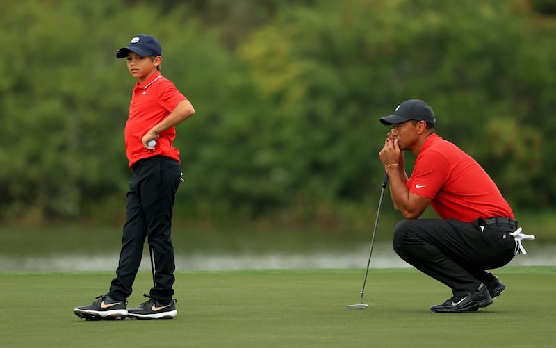 Tiger Woods and son Charlie line up a putt on the 15th hole during the final round of the PNC Championship at the Ritz Carlton Golf Club. AFP