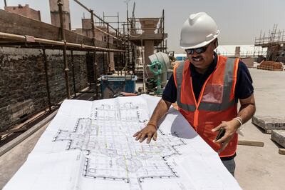 Nishit Raval, senior project manager of the Baps Hindu Mandir project, checks floor plans for numeric codes to match the carvings being installed in Abu Dhabi. Antonie Robertson / The National

