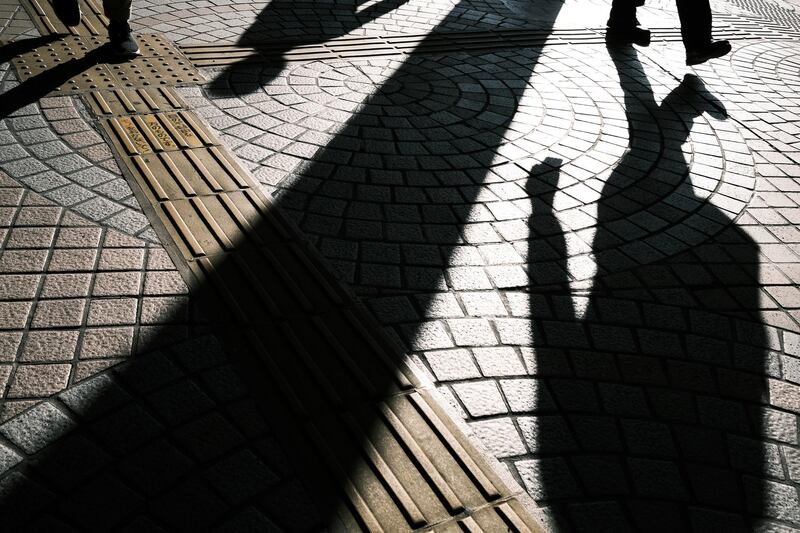 The shadows of commuters are cast on the ground in Tokyo, Japan. Bloomberg