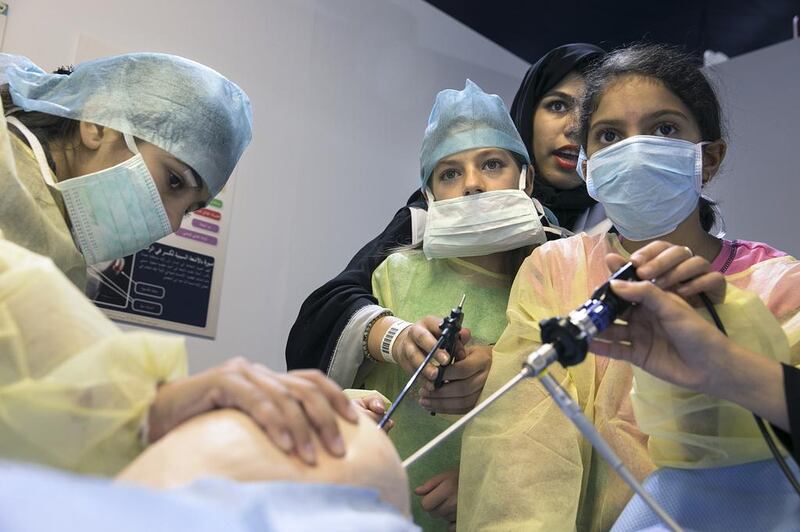 Aya Mohammed, 12, Irene Ramos, 12, and Lina Temimi, 9, operate on a medical figurine during a workshop at Abu Dhabi Science Festival. Silvia Razgova / The National 

