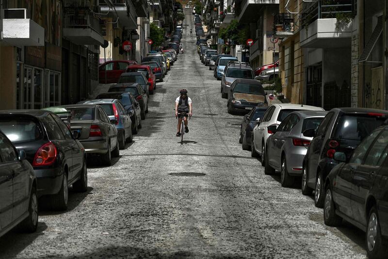 A man rides his bike in a deserted street of central Athens on a lockdown.   AFP