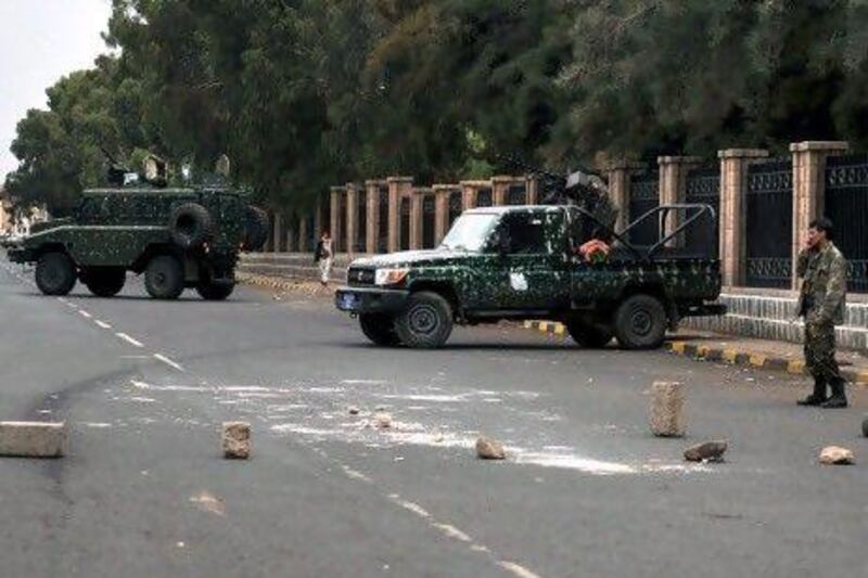 Security vehicles block the street leading to the headquarters of the Interior Ministry in Sana'a,  At least eight people have reportedly been killed in clashes between Yemeni troops and tribesmen loyal to the former president.