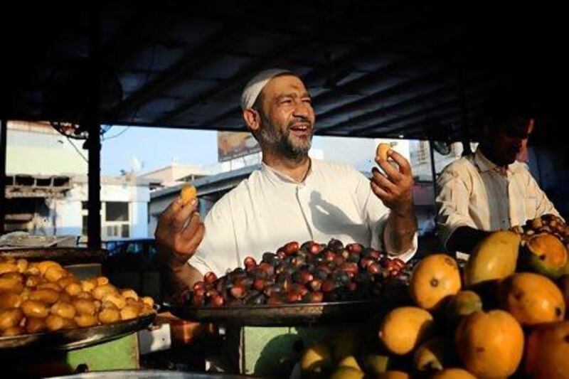 A Bahraini fruit vendor tries to attract customers in Jidhafs, west of Manama. The country's economy was forecast to grow by more than 5 per cent this year. Mohammed Al Shaikh / AFP