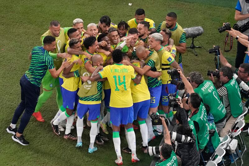 Brazil's Casemiro is mobbed by teammates after scoring. AP