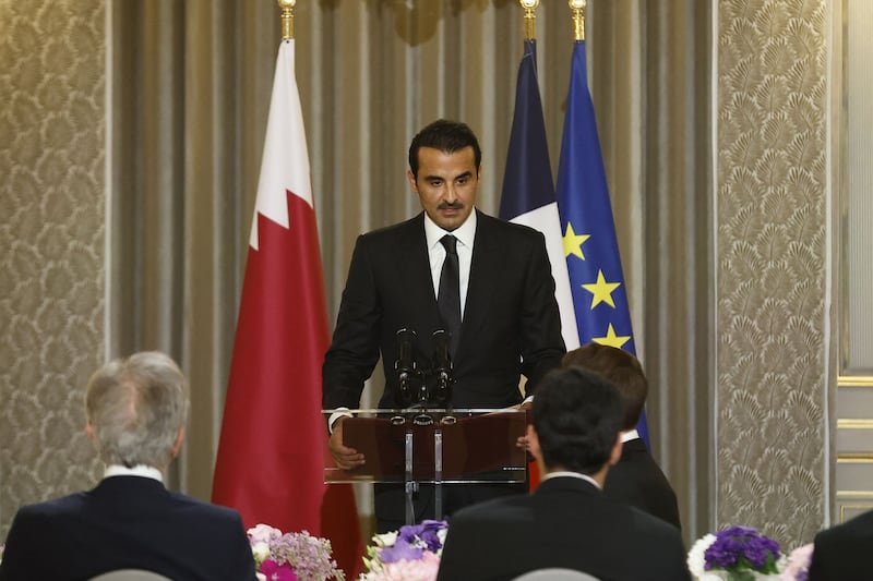 Sheikh Tamim delivers a speech before the official dinner, with flags of Qatar, France and the EU in the background. AFP