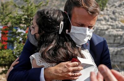 TOPSHOT - French President Emmanuel Macron hugs a blast victim while attending a ceremony to mark Lebanon's centenary in Jaj Cedars Reserve Forest, northeast of the capital Beirut, on September 1, 2020. / AFP / POOL / GONZALO FUENTES
