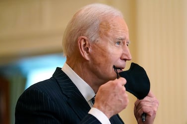 US President Joe Biden removes his face mask as he arrives to speak about Covid-19 vaccinations from the White House in Washington. AP