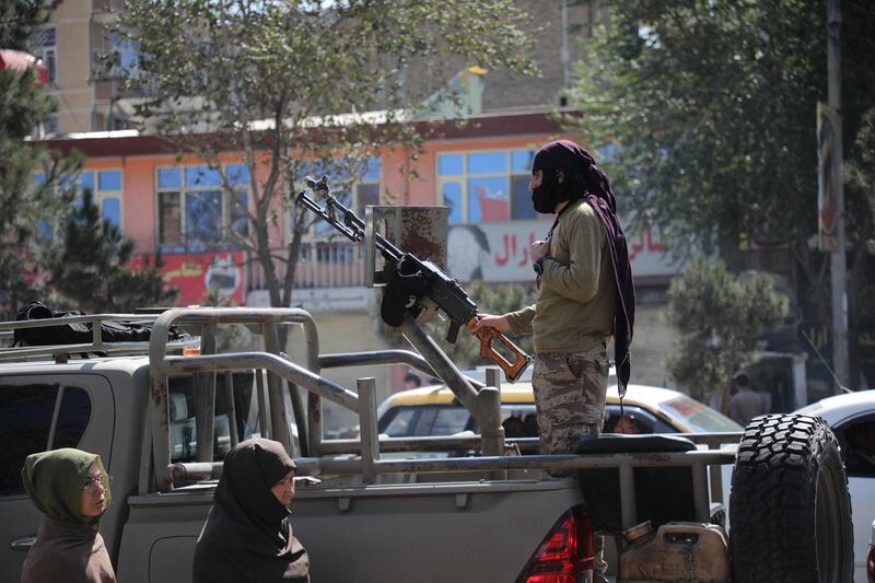 A Taliban fighter stands guard near the scene of the blast. AFP