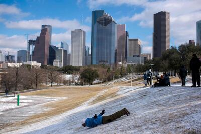 TOPSHOT - A man sleds down a snow covered hill in Houston, Texas on February 15, 2021. Much of the United States was in the icy grip of an "unprecedented" winter storm on February 15 as frigid Arctic air sent temperatures plunging, forcing hundreds of flight cancellations, making driving hazardous and leaving millions without power in Texas. Texas Governor Greg Abbott announced that the White House has issued a Federal Emergency Declaration for Texas in response to severe winter weather across the state. / AFP / AFP  / Mark Felix
