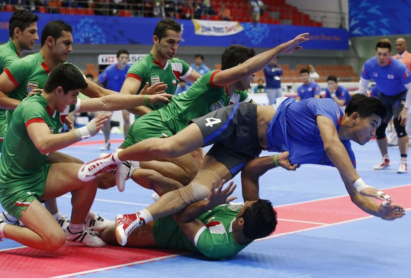 Lee Jang-kun of South Korea, in blue, is tackled by Iranian players during a kabbadi match at the 2014 Asian Games on Tuesday. Kim Kyung-hoon / Reuters / September 30, 2014