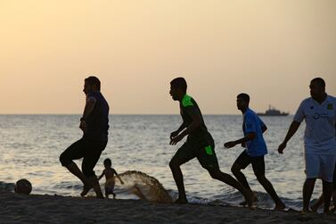 Omani youths play football on the beach at sunset on September 17, 2021, in the capital Muscat (Photo by MOHAMMED MAHJOUB  /  AFP)
