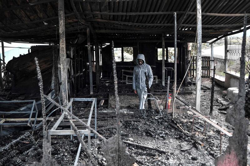 Israel from Congo, a migrant who was also a teacher of the school for refugee children walks through the burnt facilities of the school of the "One Happy Family" NGO's project on the island of Lesbos on March 8, 2020.   A fire engulfed a refugee shelter on the island of Lesbos Saturday as Greece announced further restrictions towards asylum seekers in response to a migration surge enabled by Turkey.
The fire at One Happy Family, a Swiss-operated family care centre for refugees just outside the island capital, came after violence at the weekend directed at aid groups and journalists on Lesbos.
 / AFP / LOUISA GOULIAMAKI
