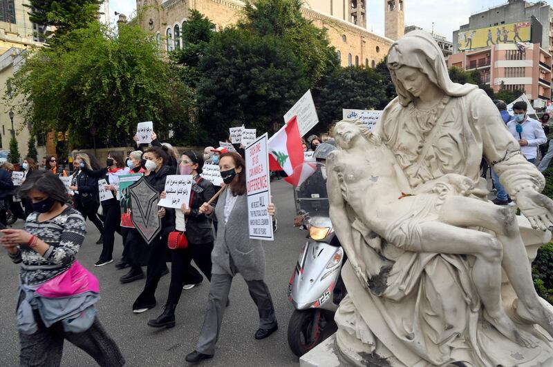 epa09086257 Lebanese women carry placards as they march on the occasion of Motherâ€™s Day under the slogan 'Mother's Cry', in Beirut, Lebanon, 20 March 2021. Mother's Day is celebrated in various countries on 21 March.  EPA/WAEL HAMZEH